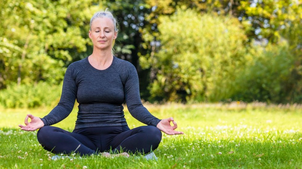 woman in a mediation pose outside
